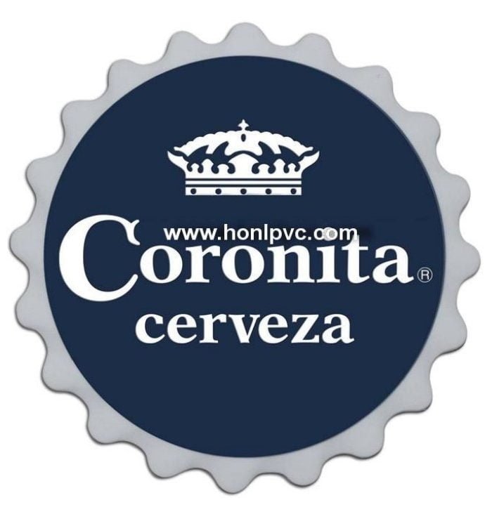 The soft rubber coaster is a round sign resembling a bottle cap, featuring “Coronita cerveza” text and a crown logo on a dark blue background, with “www.honlpvc.com” displayed across the crown.