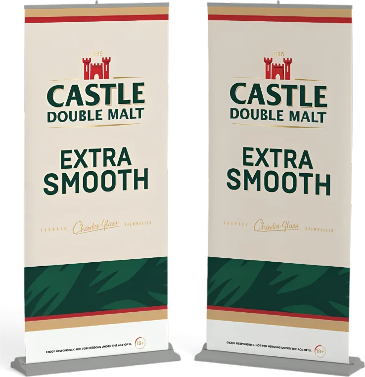 Two standing banners display the "Castle Double Malt Extra Smooth" branding with a red castle logo and green text on a cream background.