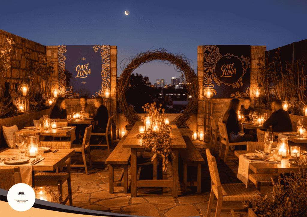 Rooftop restaurant at night with wooden tables, lit candles, and diners. Large "Café Luna" signs and a city skyline are visible in the background under a crescent moon.
